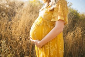 Woman experiencing early pregnancy back pain, with focus on lower back and stomach discomfort. Back pain relief tips for pregnancy can ease discomfort