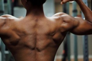 A muscular back with defined shoulder muscles, illustrating potential causes of shoulder and arm pain, including impingement and muscle strain