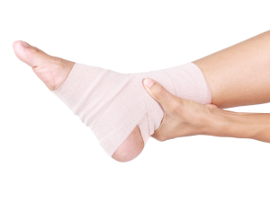 A close-up of an ankle wrapped with an elastic adhesive bandage to provide support and stability, showcasing its uses in injury recovery and joint protection