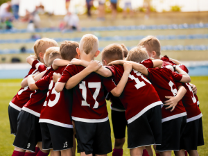 Image showing a young athlete wearing athletic arm bands and a kids arm sling for injury prevention and treatment. This image highlights arm care after vaccine arm pain and wrist support for children