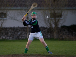 A GAA player preparing to strike a ball with a hurl, emphasizing the risks of hip injuries and ACL injuries in Gaelic games.