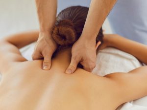 A therapist performing a neck and shoulder massage to relieve pain and tension, highlighting effective massage techniques for relaxation and pain relief.
