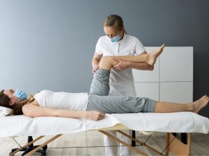 Physiotherapist treating a patient with a knee injury, demonstrating how to exercise with a knee injury and prevent knee injuries effectively