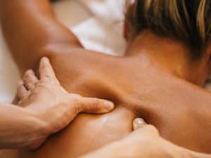 Sports massage therapist applying deep tissue techniques on the back of an athlete to relieve muscle tension and enhance recovery