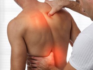Physiotherapist applying targeted massage therapy to relieve back pain and muscle tension.
