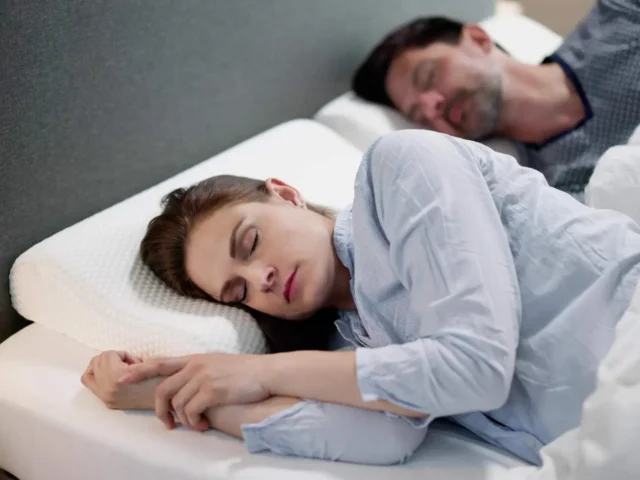 Young couple sleeping on orthopedic pillows to avoid neck and back pain in the mornitngs.