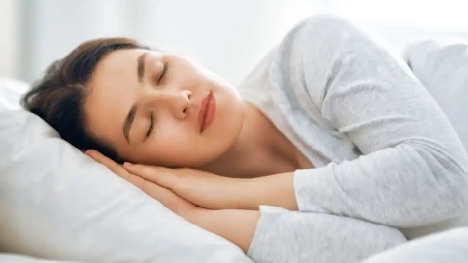 Woman sleeping on her side on a pillow that fills the gap between the head and the shoulder.