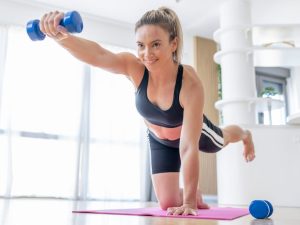 Person performing a home workout with hand weights, focusing on balance and strength, showcasing the versatility of adjustable hand weights