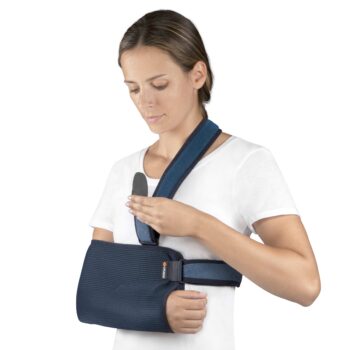 Woman adjusting a Shoulder and Arm Immobiliser Sling with blue straps for injury support.