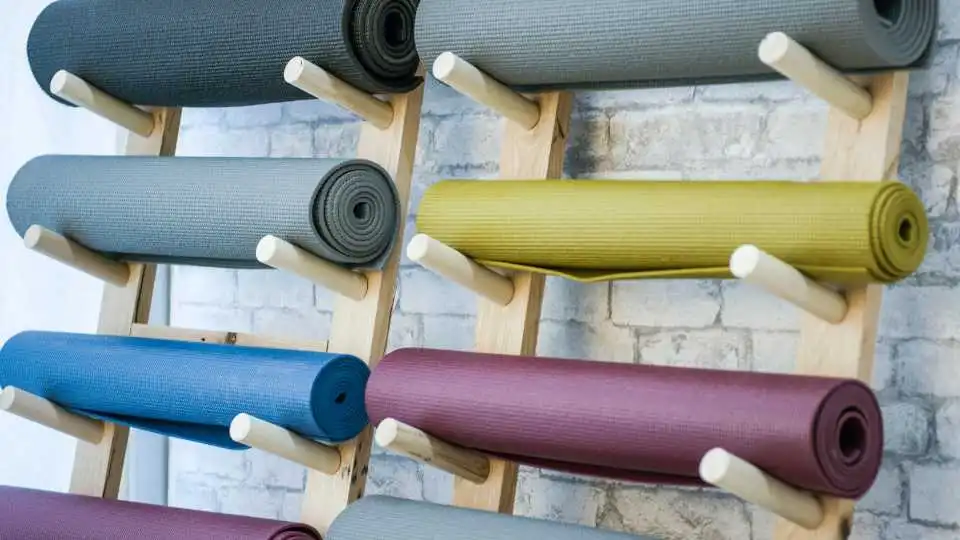 Racks with different colours and different size yoga mats. 