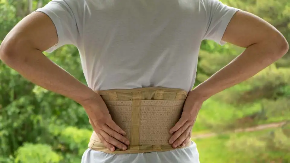 Woman wearing a beige back brace post surgery as prescribed by her doctor.