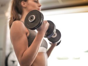 Close-up of a person performing a bicep curl with a dumbbell, highlighting the differences between dumbbells and barbells for strength training