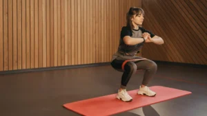 Woman using elastic resistance bands for squads.