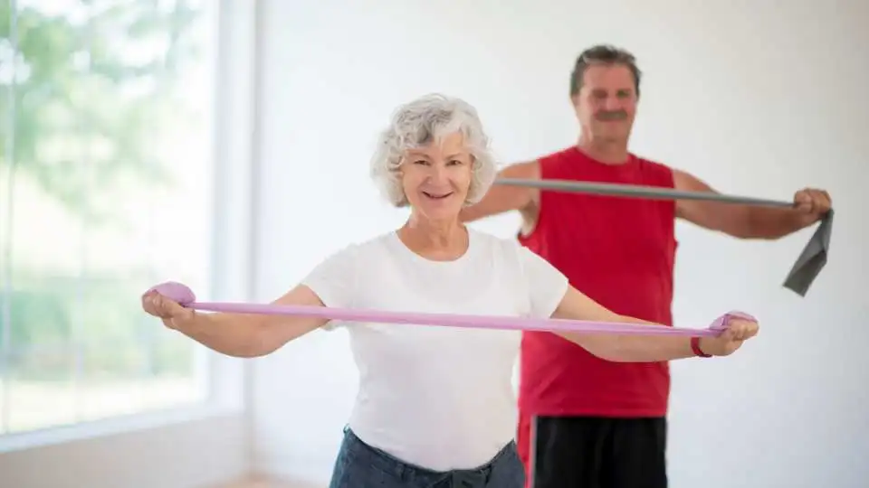An older couple exercising using resistance bands.
