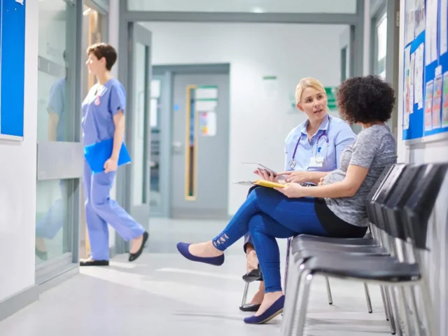 Inside a physio clinic. A physio specialist consulting with a patient in the corridor.
