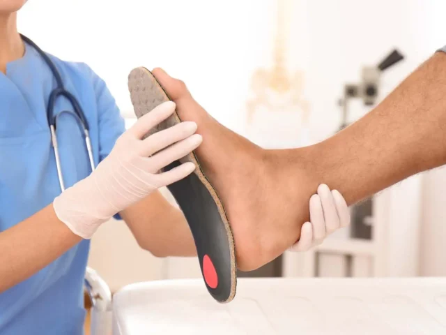 A footcare specialist is checking if the insole for flat feet matches the size of a patient.