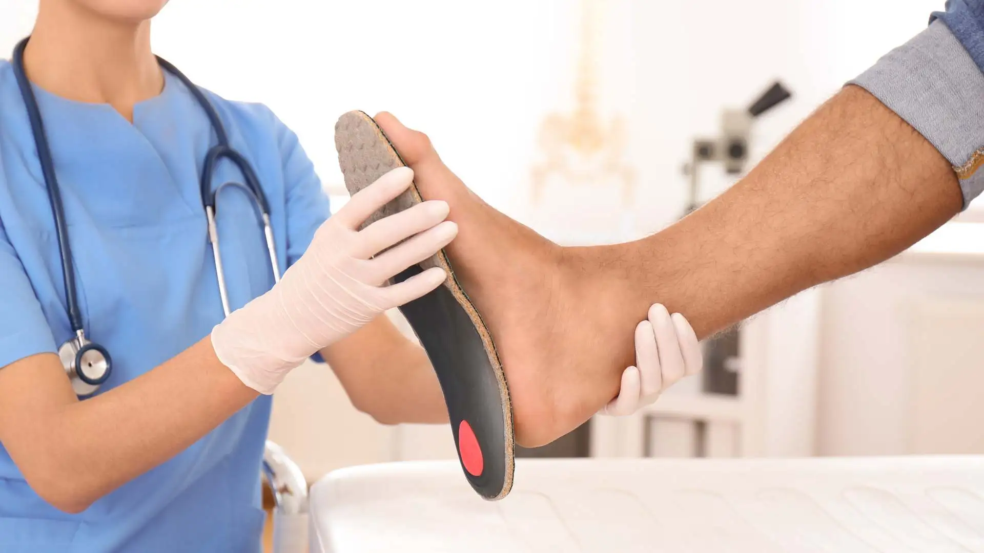 A footcare specialist is checking if the insole for flat feet matches the size of a patient.