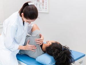 Chiropractor adjusting a patient on an electric treatment table, ensuring precise positioning and optimal comfort during therapy