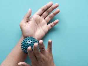 Person using a massage ball on their back and neck to relieve pain and muscle tension. Ideal for targeted therapy and relaxation.