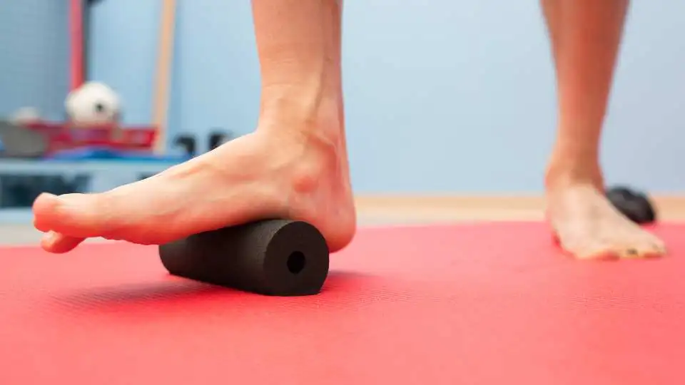 A man using foot roller to reduce stiffness in the plantar fascia.