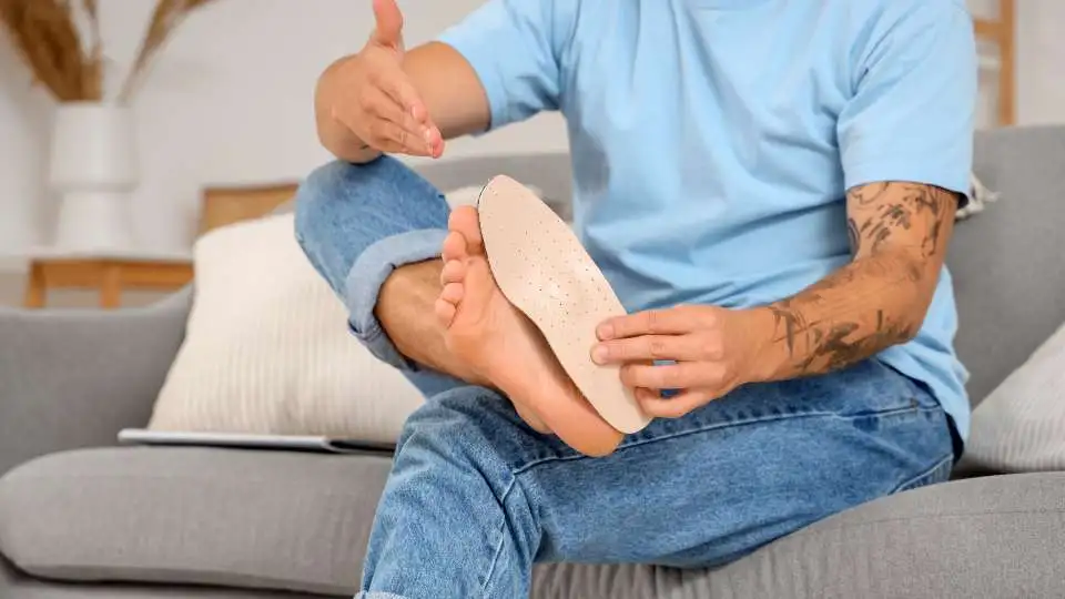 A man checking if his foot is flat an measuring an insole.