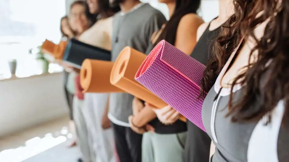 Group of yoga students bringing their professional yoga mats to the studio.