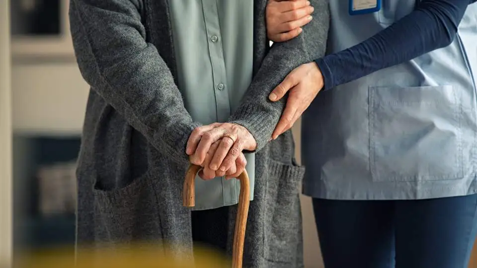 Woman using a walking stick at home.