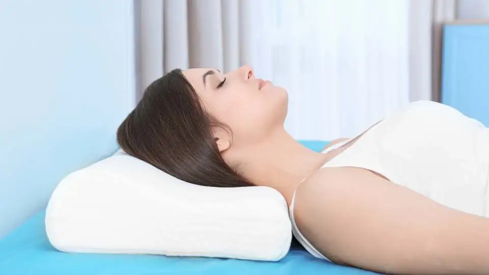 A woman sleeping on orthopedic pillow to support her neck overnight.