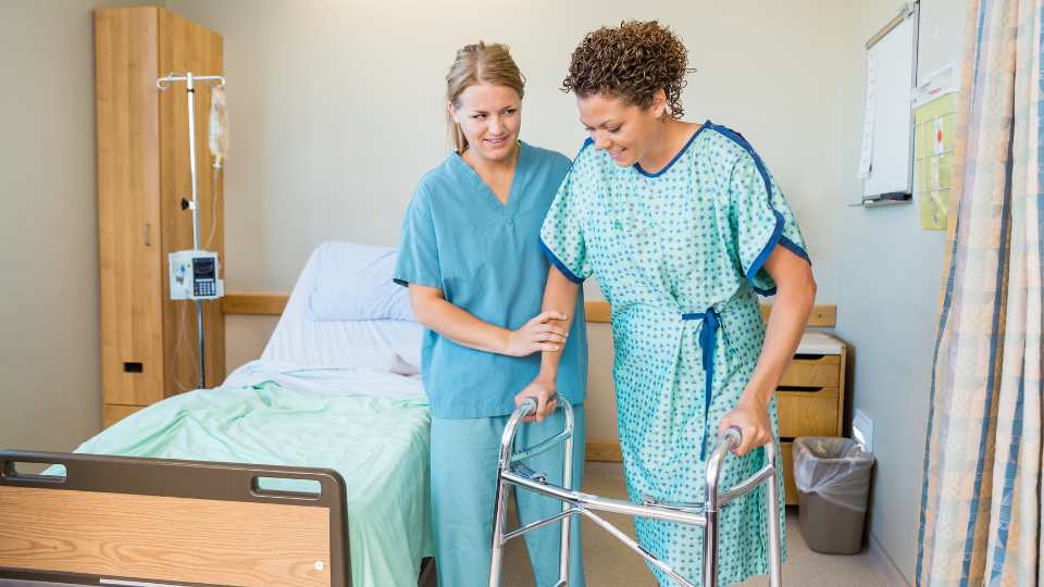 Young woman testing a zimmer frame in the hospital after she had a treatment.