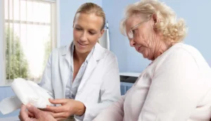 A doctor explains to a patient how to dispose off incontinence pads at home.