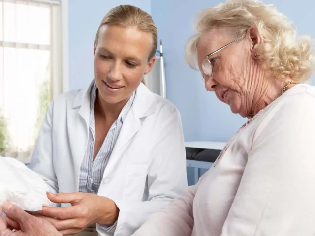 A doctor explains to a patient how to dispose off incontinence pads at home.