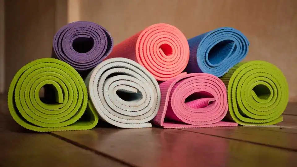 Pile of thick 1cm yoga mats in different colours.