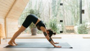 Young female demonstrates how to use a yoga mat for physical therapy and stretching.