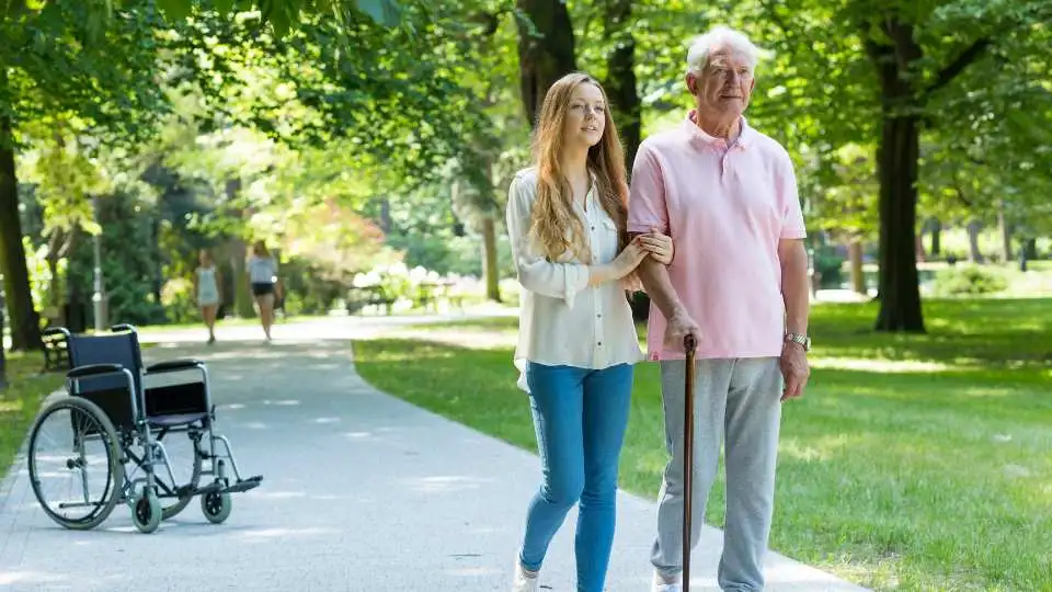 Elderly man using a walking stick in the park just for a short walk.