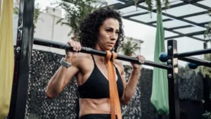 A woman doing assisted pullups using resistance bands at the street gym.