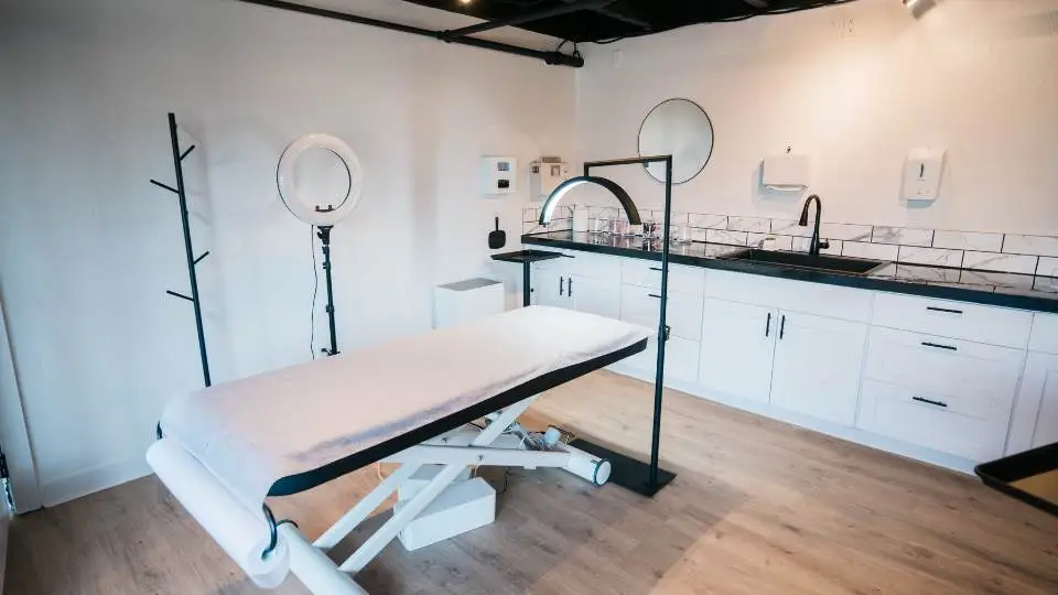 Physio cabinet setting with disposable couch roll, a treatment table and a box of disposable gloves.