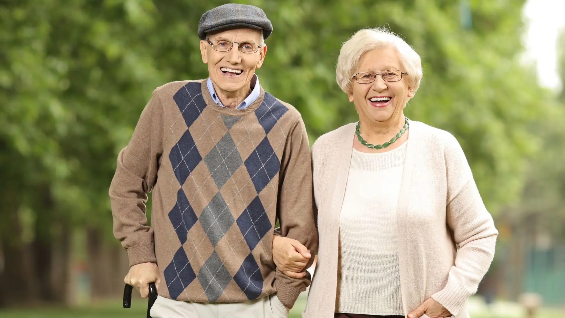 Elderly couple walking in the park. The male feels comfortable wearing incontinence pads.