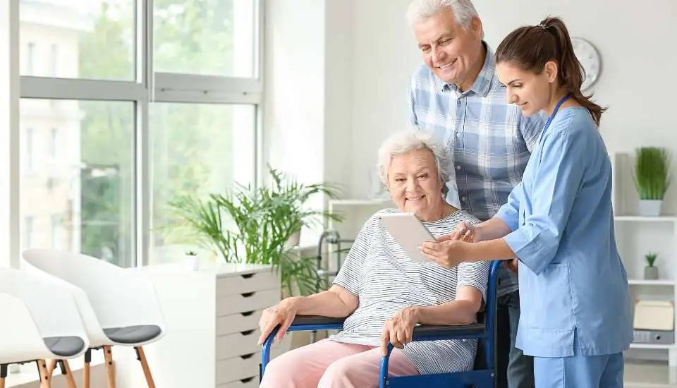 Care worker explains to an elderly couple and a lady with reduced mobility about incontinence aids.