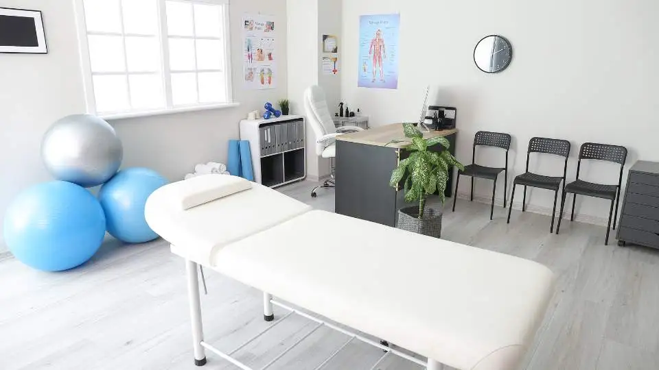 Inside physios cabinet where we can see massage oils treatment tables and other seating options.