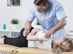 Physiotherapist performing treatment on a patient using a professional massage and physiotherapy table for effective rehabilitation and therapy.