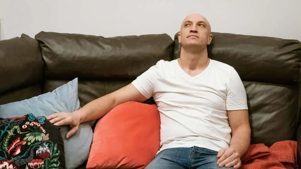 A man sitting on a sitting ring to help prevent nerve compression.