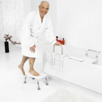 Elderly man using a bathtub step to get into the bath.