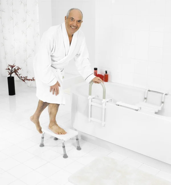 Elderly man using a bathtub step to get into the bath.