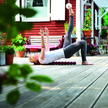 Woman lying on the Sissel Spinefitter, lifting her hips (bridge pose) for muscle activation