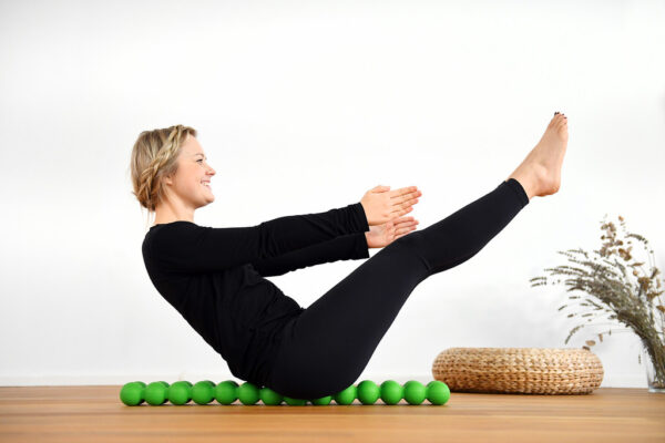 Person using the Sissel Spinefitter, lying back on dual pressure-point rollers for spinal relief