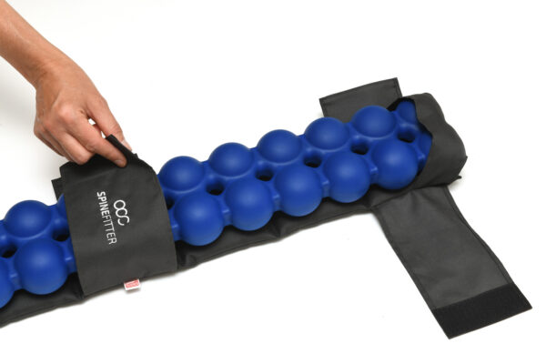 Linseed-filled Sissel Spinefitter Linum Hot/Cold Pillow placed alongside the blue Spinefitter device for targeted back therapy.