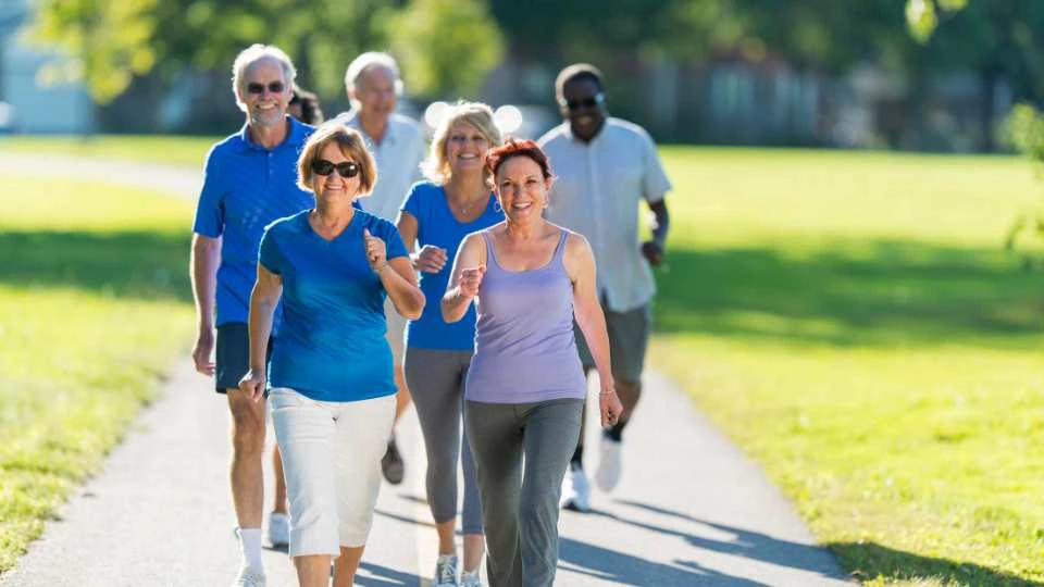 Group of elderly walking in the park not concerned about their incontinence issues.