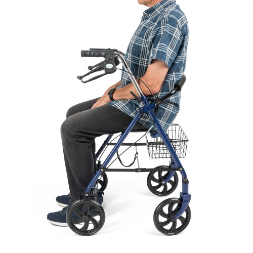 Side view of an older man sitting on a blue rollator walker with a wire basket underneath, demonstrating the built-in seat function.