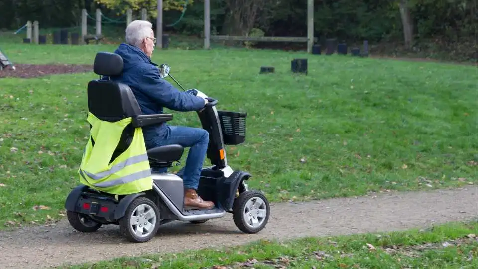 A man enjoying the nice weather outside using a mobility scooter.