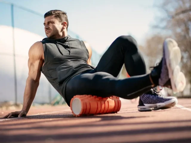 Young athlete using a trigger point foam roller to help with tight muscle relief.